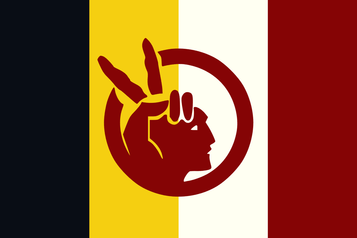 The AIM flag. Black, yellow, white, maroon vertical stripes in background. Overlaid in maroon: cut out/stencil representation of human face with fingers in place of headdress - suggests a peace sign.