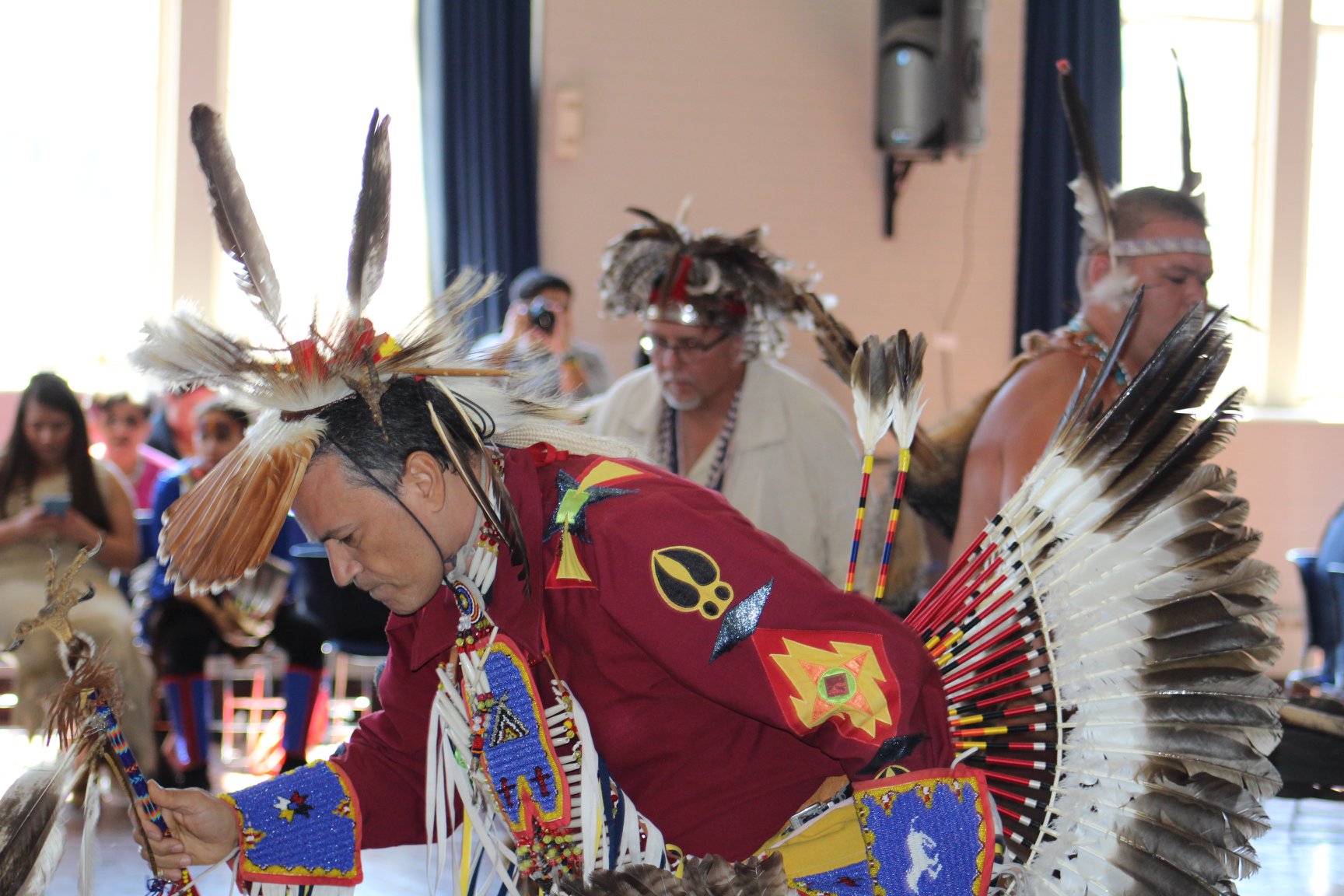Color photograph showing two male Native American dancers in ceremonial attire in motion at the 2019 American Indian Students Association (AISA) Powwow at William & Mary. Photo by Christian Busch.