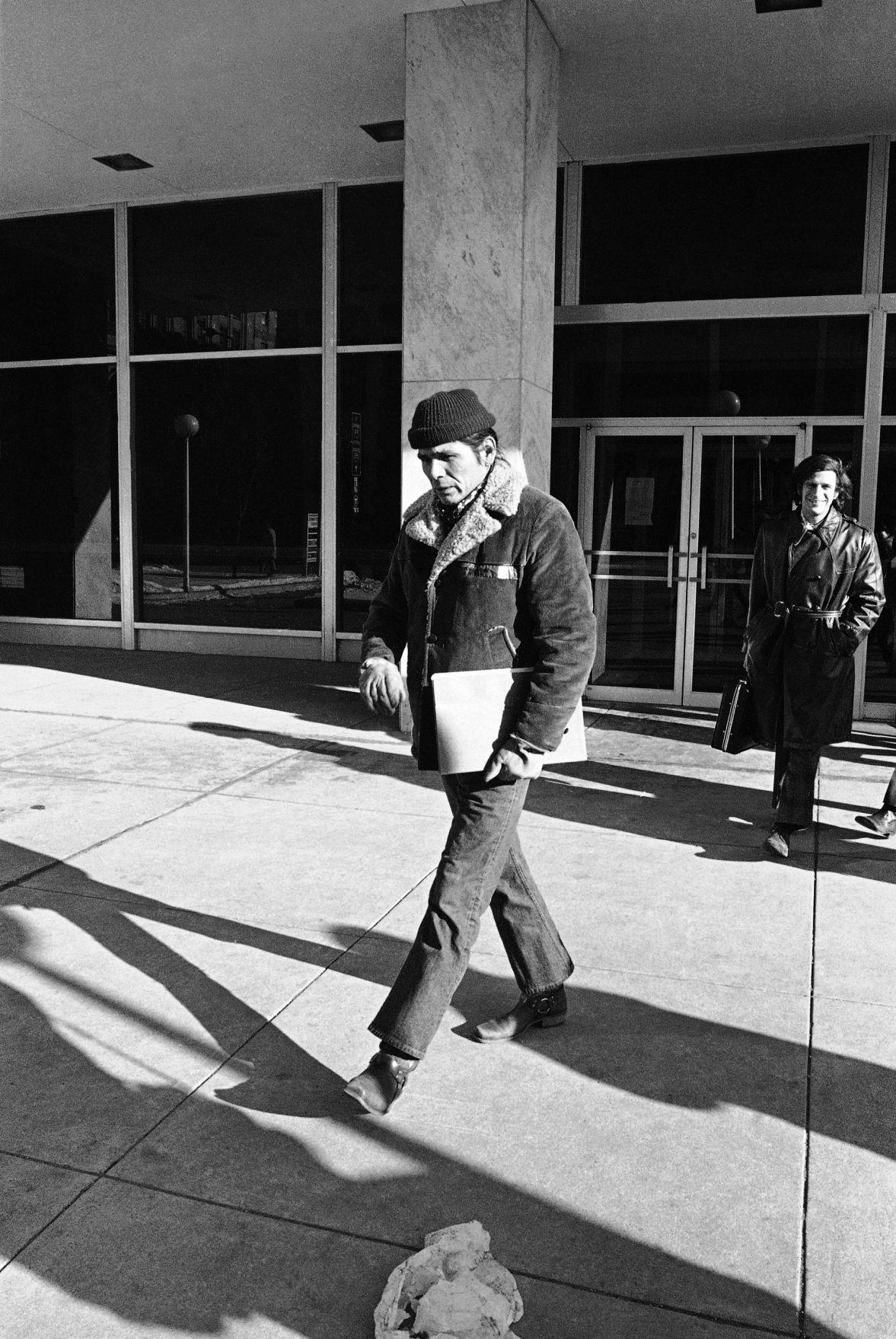 Black and white photograph of Dennis Banks leaving the Federal Court Building in St. Paul, Minnesota.