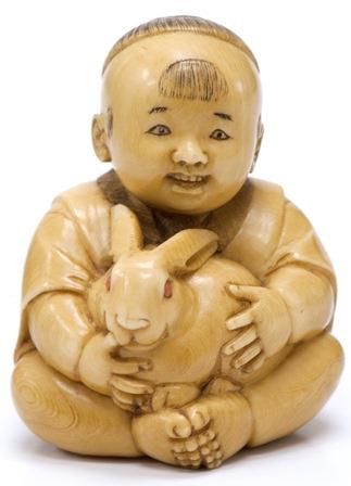 Netsuke of a boy holding a rabbit